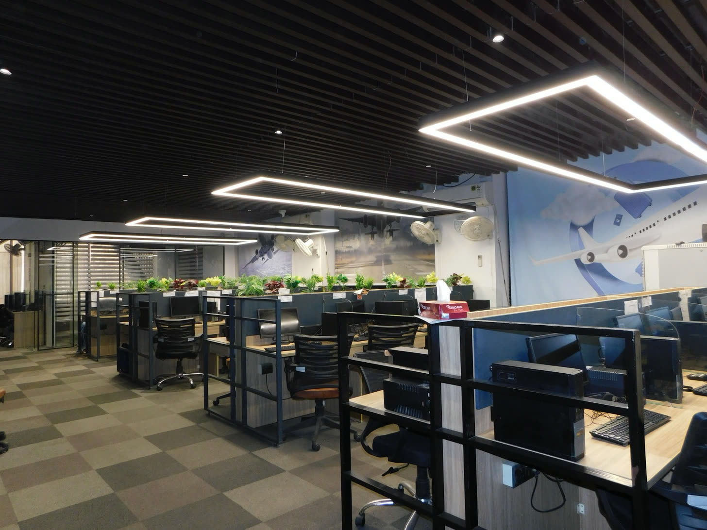 The same office floor at handover: workstations installed, linear lighting, finished flooring and services complete
